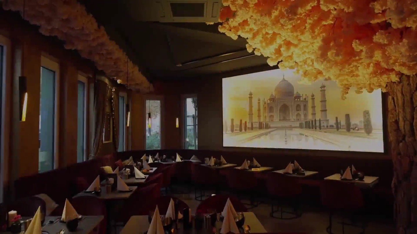 Gastraum des Royal Tandoor mit Taj-Mahal-Wandbild, Blütenbaum und gedeckten Tischen